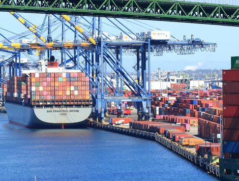 A LARGE CONTAINER SHIP IS DOCKED NEXT TO CRANES AT THE PORT OF LOS ANGELES.